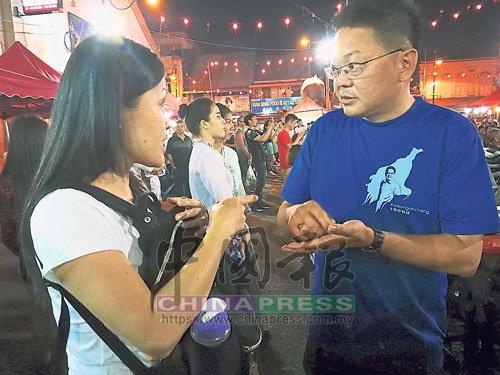 中国侨网杜绳祯（右）在活动现场并为市民解答疑问。（马来西亚《中国报》）