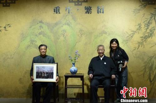 中国侨网南京大屠杀幸存者家属和摄影师在纪念馆内摄影留念。　蔡美婷　摄