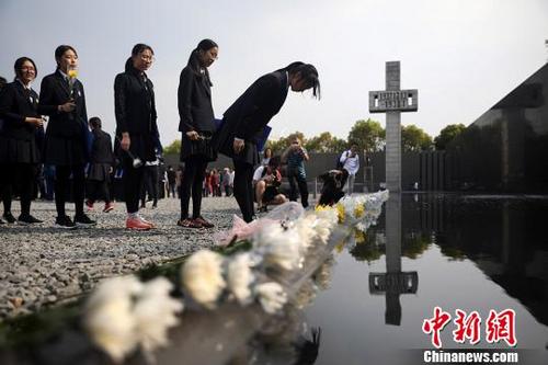 中国侨网中学生向南京大屠杀遇难同胞纪念碑鞠躬。　泱波　摄