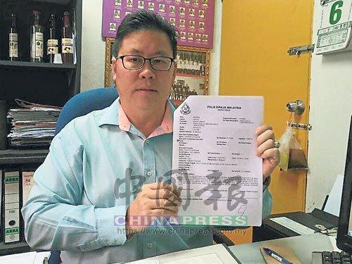 中国侨网都赖州议员钟绍安手持报案纸，提醒民众勿上当受骗。（马来西亚《中国报》）