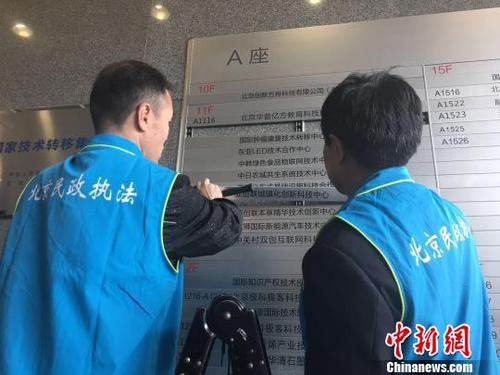 中国侨网北京市民政局联合北京市公安局对非法社会组织进行集中取缔。图为执法人员拆除非法社会组织标识。杜燕　摄