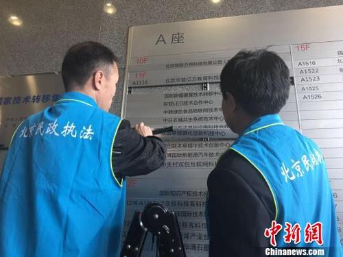 中国侨网北京市民政局联合北京市公安局对非法社会组织进行集中取缔。图为执法人员拆除非法社会组织标识。杜燕 摄