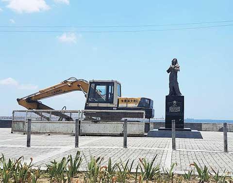 中国侨网一辆挖掘机出现在菲律宾“慰安妇”铜像后面，据称要拆除该铜像。(图片来源：《菲律宾商报》)