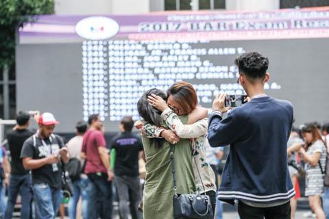 中国侨网图为一名女子昨日（26日）在大理院得知自己律师会考及格后，激动地抱着妹妹。共有6748人参加去年11月的会考，只有25.5%或1724人及格。（《菲律宾商报》）