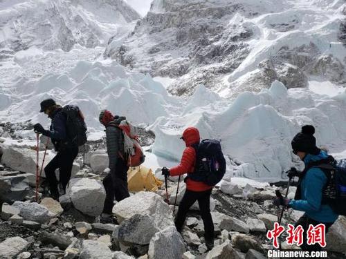 中国侨网孙晓明(红衣者)与队友们在珠峰登山途中。 受访者供图 摄