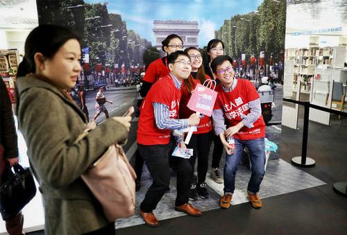 中国侨网4月14日,在“法国高校春季见面会”活动中担任志愿者的留法归国学生通过体感相机与“凯旋门”合影。(法国欧洲时报网/李雪峰 摄)