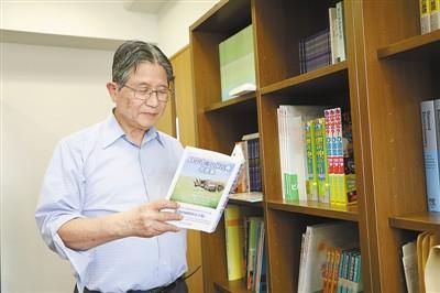 中国侨网藤岛昭在东京理科大学办公室里翻阅其撰写的《科学家与中国古典名言集》一书。记者 刘军国摄