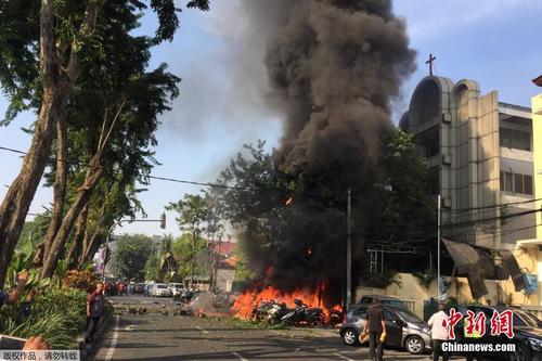 中国侨网当地时间5月13日上午，印尼第二大城市泗水的3座教堂接连遭遇炸弹袭击，据印尼国家警察总长迪托将军称，3起爆炸“造成至少13人死亡，40多人受伤”。图为泗水市中心的五旬节教堂遭遇炸弹袭击后，附近的摩托车燃起大火。