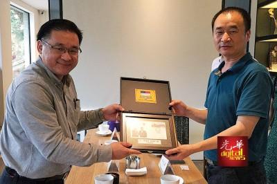 中国侨网鸡场街文化坊工委会顾问颜天禄(左)赠送纪念品给宽窄巷子管委会副总经理冉红山。(马来西亚光华网图片)
