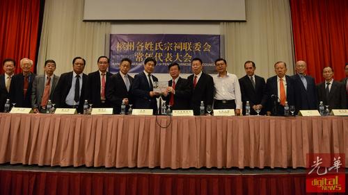 中国侨网张威如(左7)赠送纪念品予曹观友(左8)。(马来西亚《光华日报》)