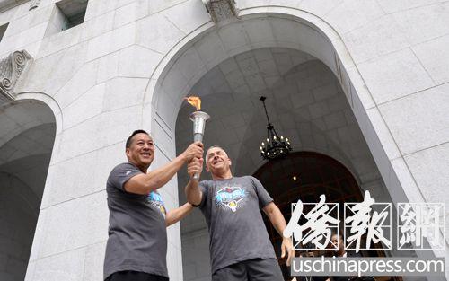 中国侨网南加夏季特奥会即将召开,图为洛杉矶市警局华裔最高阶警官周宝来在将火炬传递给洛杉矶县警局的火炬手。(美国《侨报》/邱晨 摄)