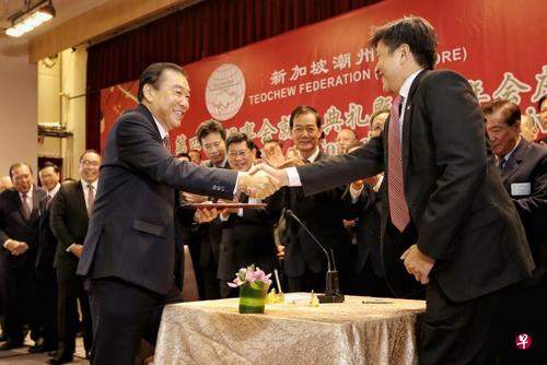 中国侨网新加坡潮州总会会长谢楚明(左)率领第四届理事会全体理事宣誓就职后,与见证仪式的主宾总理公署部长黄志明(右)握手。(新加坡《联合早报》/徐颖荃 摄)