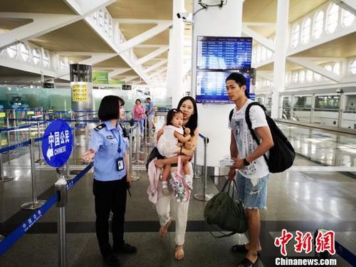 中国侨网边检工作人员正引导旅客走中国公民通道。