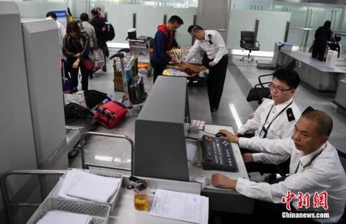 中国侨网资料图:图为福州海关隶属长乐机场海关关员对入境旅客实施过机查验。 中新社记者 张斌 摄