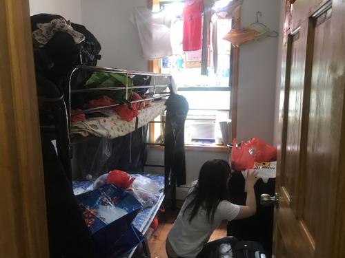 中国侨网惨案发生后，家中一片狼藉，受害女子的姐姐帮忙收拾屋内物品。(美国《世界日报》/牟兰 摄)