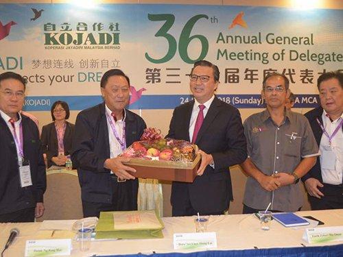 中国侨网自立合作社主席黄炳火(左2起)赠送纪念品给廖中莱。(马来西亚《中国报》)