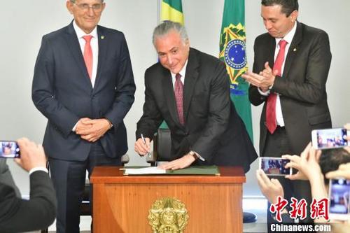中国侨网图为巴西总统特梅尔（中）在总统府签署“中国移民日”法令。　钟小新　摄