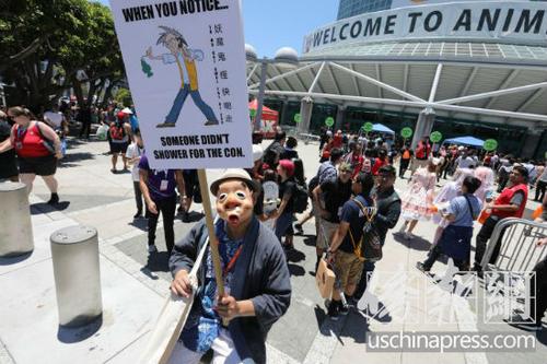 中国侨网华人范先生在会展中心前举牌。（美国侨报网/邱晨 摄） 