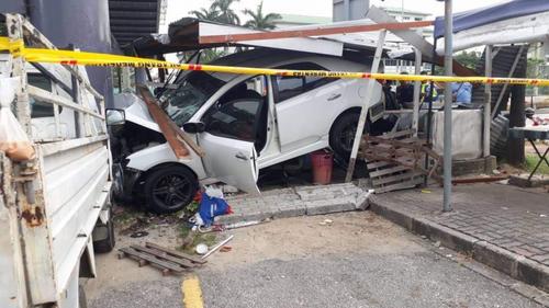 中国侨网这辆失窃轿车撞向路边食档后，再撞向行人天桥柱子，毁坏不堪。（马来西亚《星洲日报》）