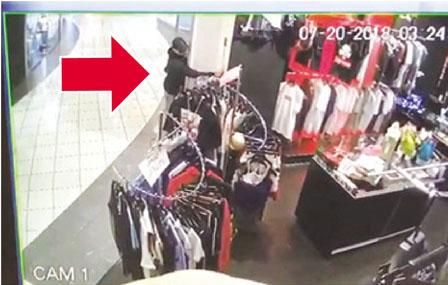 中国侨网闭路电视录下的小偷（箭头示）伸手作案画面。（加拿大《明报》）