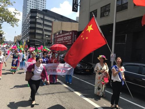 中国侨网纽约华人社区游行队伍是在五星红旗带领下，后面跟着的纽约歌舞团身着中国少数民族服饰。 (美国《世界日报》／和钊宇 摄)