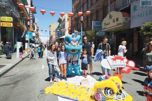 中国侨网旧金山市民与家人出席“华埠文化星期天”时,与舞狮一同合照。(美国《星岛日报》/邱凯蓝 摄)