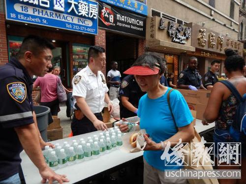 中国侨网吴铭恒向民众发放免费美食和饮品。（美国《侨报》/尹英姿 摄）