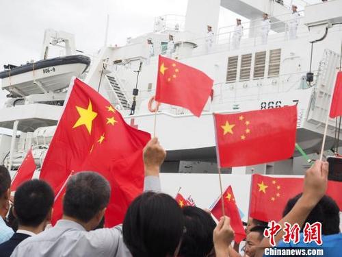 中国侨网当地时间8月9日，在斐济苏瓦港码头，华侨华人挥动中斐两国国旗，为中国海军和平方舟医院船送行。　江山　摄