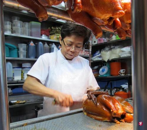 中国侨网萧佩玲向父亲学习如何制作油鸡，从准备材料、烹煮到斩鸡肉，她凡事都亲力亲为。（新加坡《联合早报》档案照）