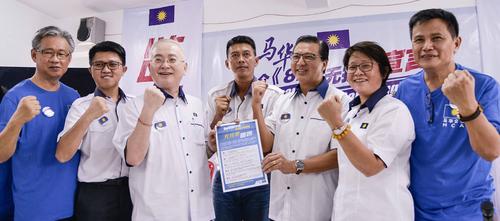 中国侨网廖中莱（左5）移交“828无拉港宣言”予无拉港候选人陈志忠（左4）。（马来西亚《光华日报》）