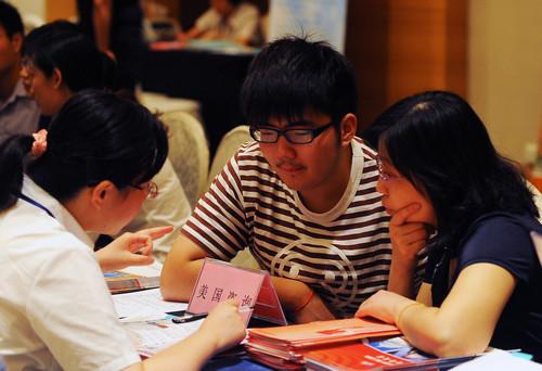 中国侨网资料图：一名家长带孩子在咨询赴美留学情况。新华社记者 陈琪 摄