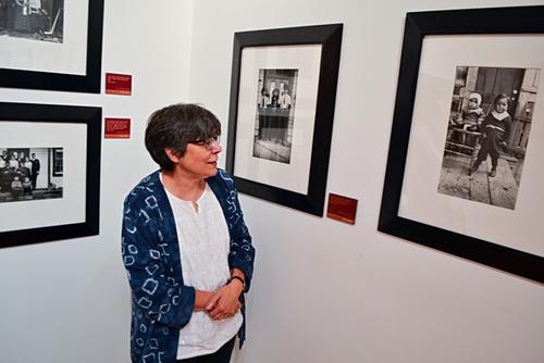 中国侨网加拿大奎斯尼尔博物馆经理亨特观赏周东海其中两幅作品。她右边第一幅拍下三名身穿牛仔装的原住民。（加拿大《星岛日报》/冯瑞熊 摄）