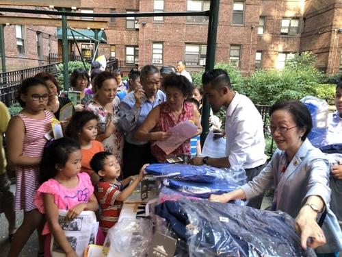 中国侨网纽约市议员陈倩雯(右一)与Cherry Green Property Corp 4日在尼克村派送100多个书包。（美国《世界日报》／颜嘉莹 摄）
