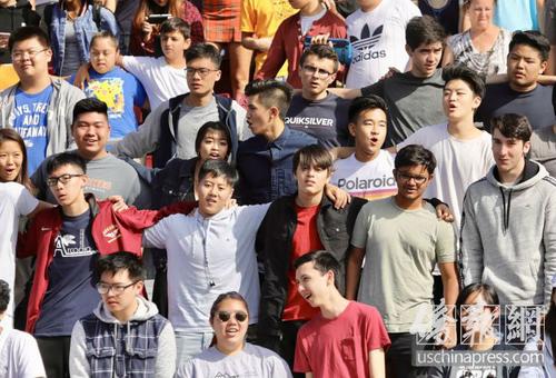 中国侨网亚凯迪亚高中学生在“9·11”恐袭事件纪念仪式上相互挽起手臂，表达团结一致战胜困难的信心。（美国《侨报》/邱晨 摄）
