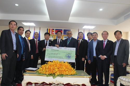 中国侨网柬华理事总会会长方侨生代表把善款移交给温本莫尼洛。（柬埔寨《星洲日报》）