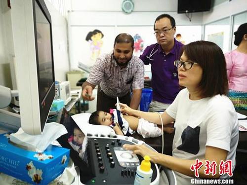 中国侨网图为云南阜外心血管病专家正在为患儿做心脏超声检查。主办方供图