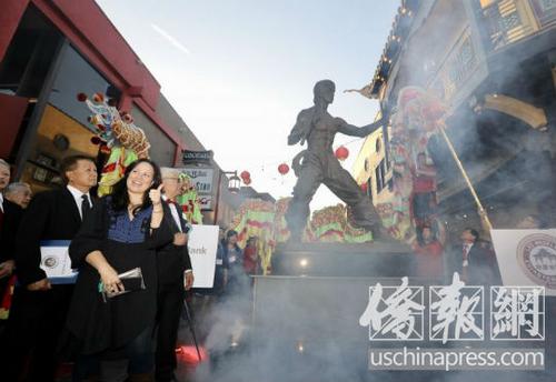 中国侨网李小龙的女儿李香凝（左侧）在父亲铜像前竖起大拇指。（美国《侨报》/邱晨 摄）