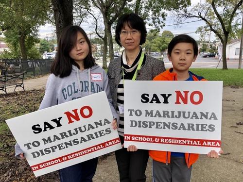 中国侨网美国加州华裔家长张秀静(中)和她的两个孩子一起加入集会。(美国《世界日报》/朱蕾 摄)