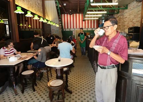 中国侨网何九品尝着海南茶，怀念老味道。（马来西亚《星洲日报》）