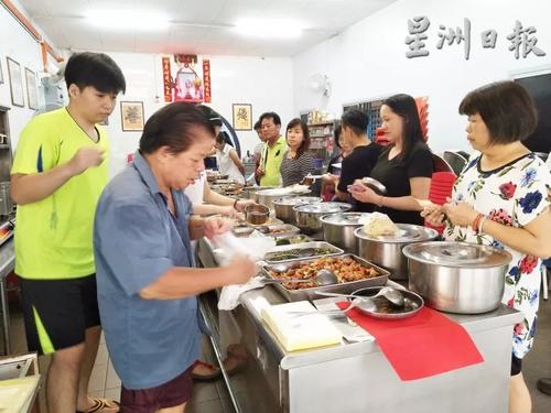 中国侨网许瑞安(左)主厨开业了34年,每天傍晚开档,前来打包晚餐便菜的家庭主妇,站得满满。(马来西亚《星洲日报》)