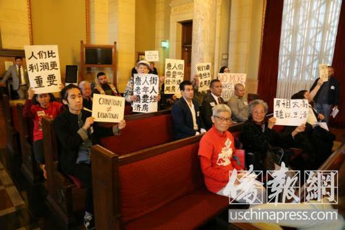 中国侨网华裔居民涌入市府会议厅举牌抗议。(美国侨报/高睿 摄)