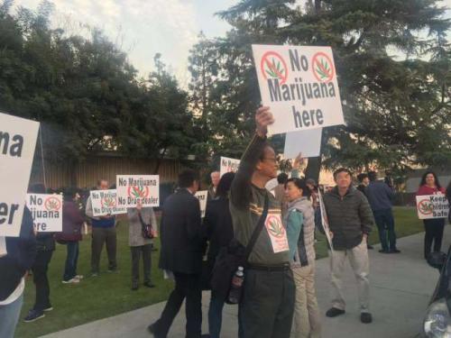 中国侨网民众在艾尔蒙地市议会举行前在门外抗议建设大麻基地。(美国《世界日报》/林佩锦 摄)