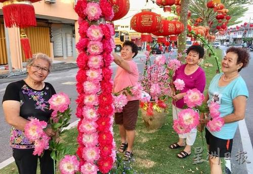 中国侨网新村的妇女们开心参与布置，把大街的树布置成了“花树”。（图片来源：马来西亚《星洲日报》）