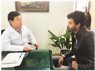 中国侨网 图为喇杰廉(左)在“中国针灸中心”接待当地患者。 (照片由喇杰廉本人提供)