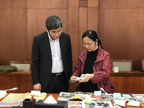 中国侨网招思虹向中国人民抗日战争纪念馆馆长李宗远介绍文物。(中新社记者 冉文娟 摄)