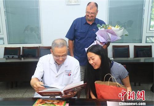 中国侨网孔姗姗赠送成长相册 。 陈红明 摄
