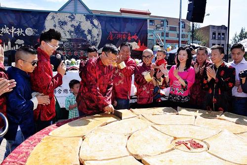 中国侨网“芝加哥中秋嘉年华”首次出现“千人大月饼”。图为主办单位福建商会联合总会会长郑时坦在开切月饼。(《芝加哥华语论坛》/张大卫 摄)