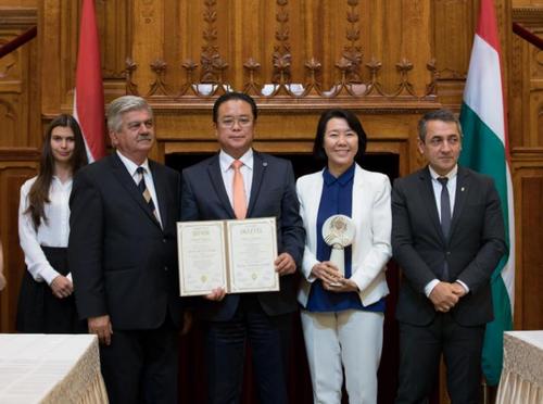 中国侨网匈牙利总理府国务秘书阿尔巴德(右一)、农业部副部长Sándor Farkas(左一)为匈牙利东方国药集团创始人陈震博士(左二)及王帆博士(右二)颁发奖杯及荣誉证书。