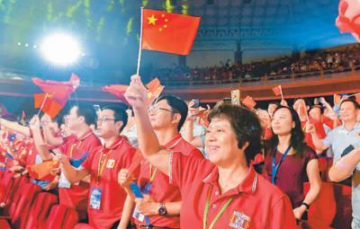 中国侨网　9月7日，粤港澳大湾区职工庆祝中华人民共和国成立70周年暨澳门特别行政区成立20周年文艺汇演在广州中山纪念堂上演，演出由广东省总工会、香港工会联合会、澳门工会联合总会联合主办。图为现场观众挥动五星红旗，合唱《我和我的祖国》。中新社记者 陈骥旻摄