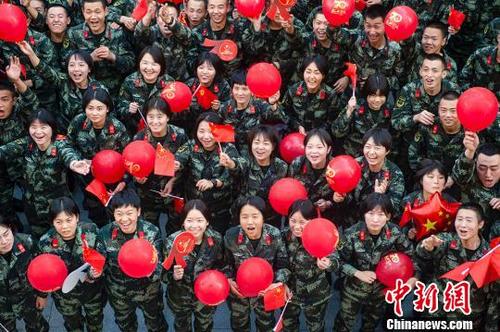 中国侨网武警官兵手拿气球、国旗，欢呼祝福祖国。　侯崇慧　摄